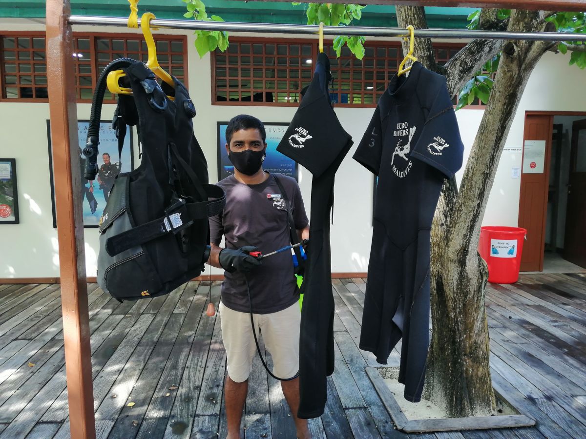 Team member cleaning wet suits at Vilamendhoo Island Resort & Spa in the Maldives