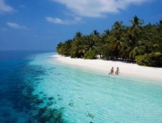 Couple on a beach at Vilamendhoo Resort in the Maldives