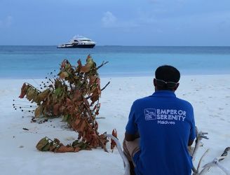 Crew member looking out to Emperor Serenity liveaboard in the Maldives