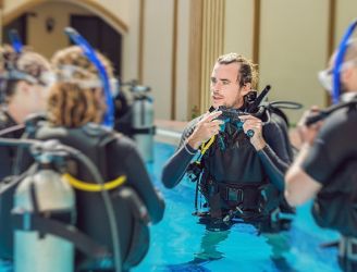 Male instructor teaching dive students in a pool in Egypt
