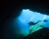 Divers by a cave entrance in Malta