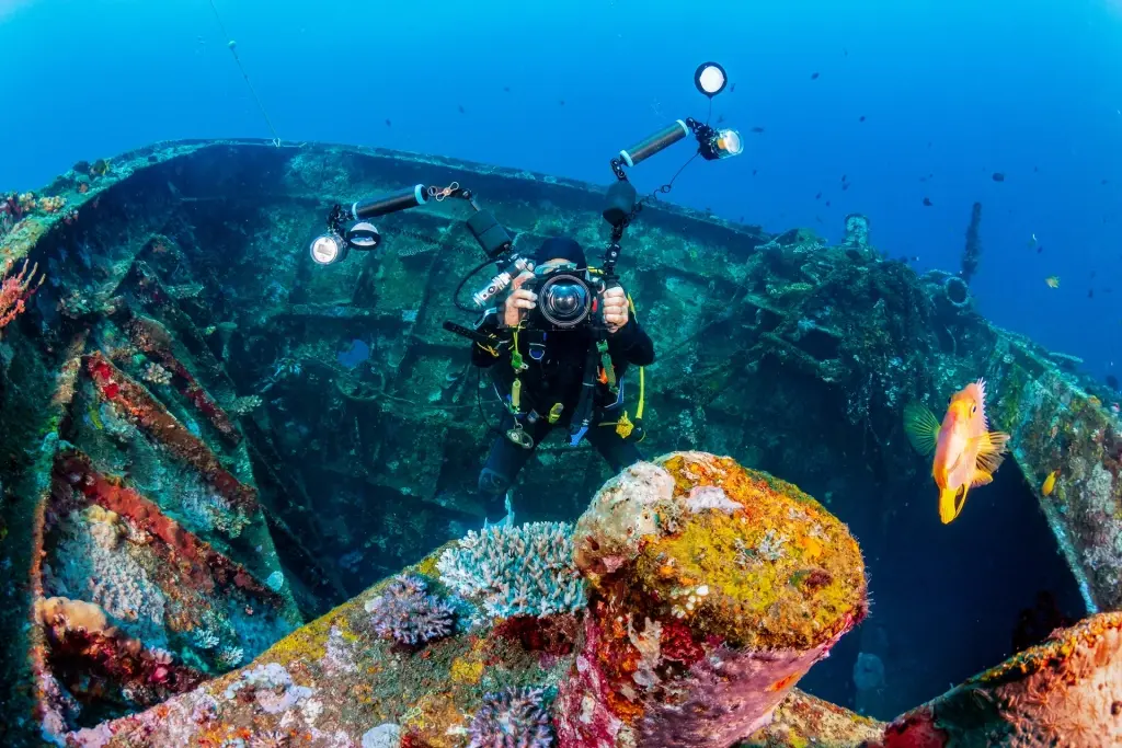 Underwater photographer exploring a wreck in Tulamben, Bali, Indonesia