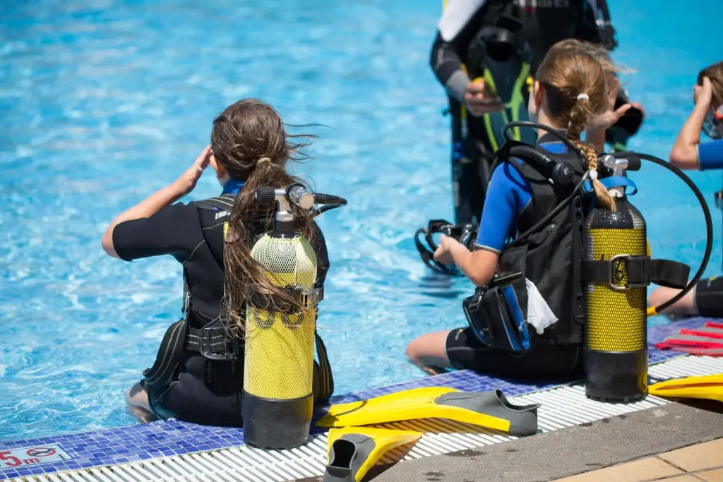 Girls learning to dive in a swimming pool on holiday