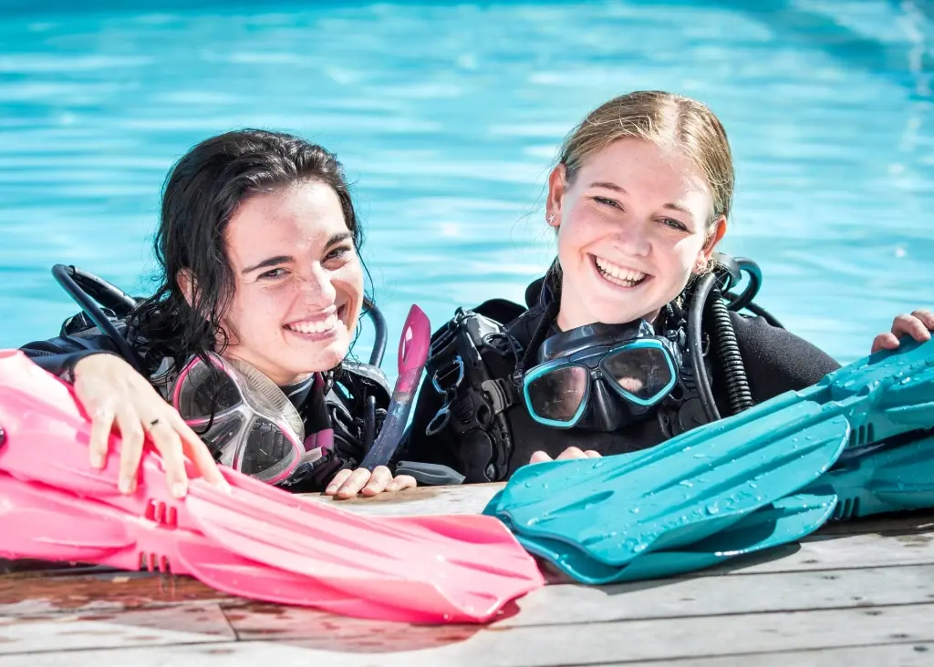 Girls learning to dive in a swimming pool on holiday
