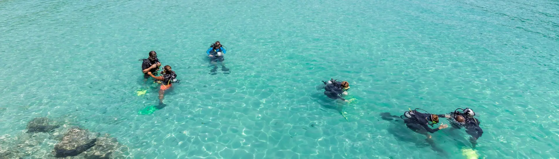 Group of people learning how to dive in the ocean