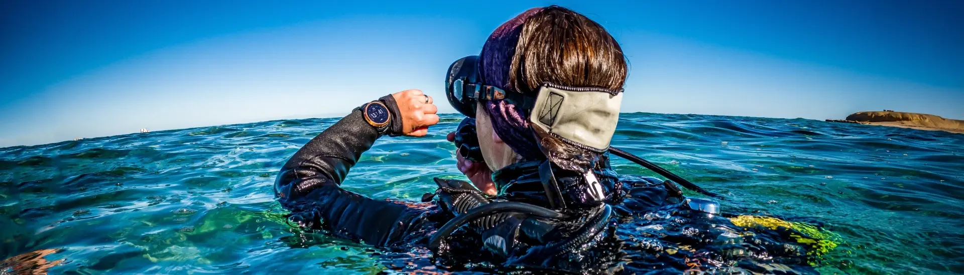 Scuba diver checking their dive computer in the sea