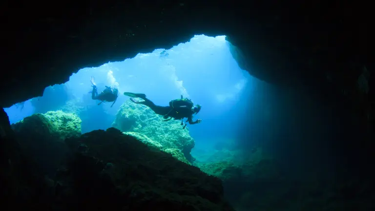 Divers investigating a cave in Malta