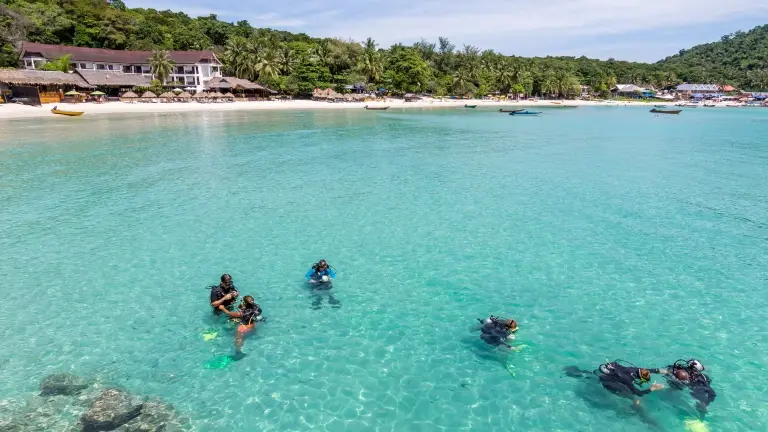 Group of people learning how to dive in the ocean