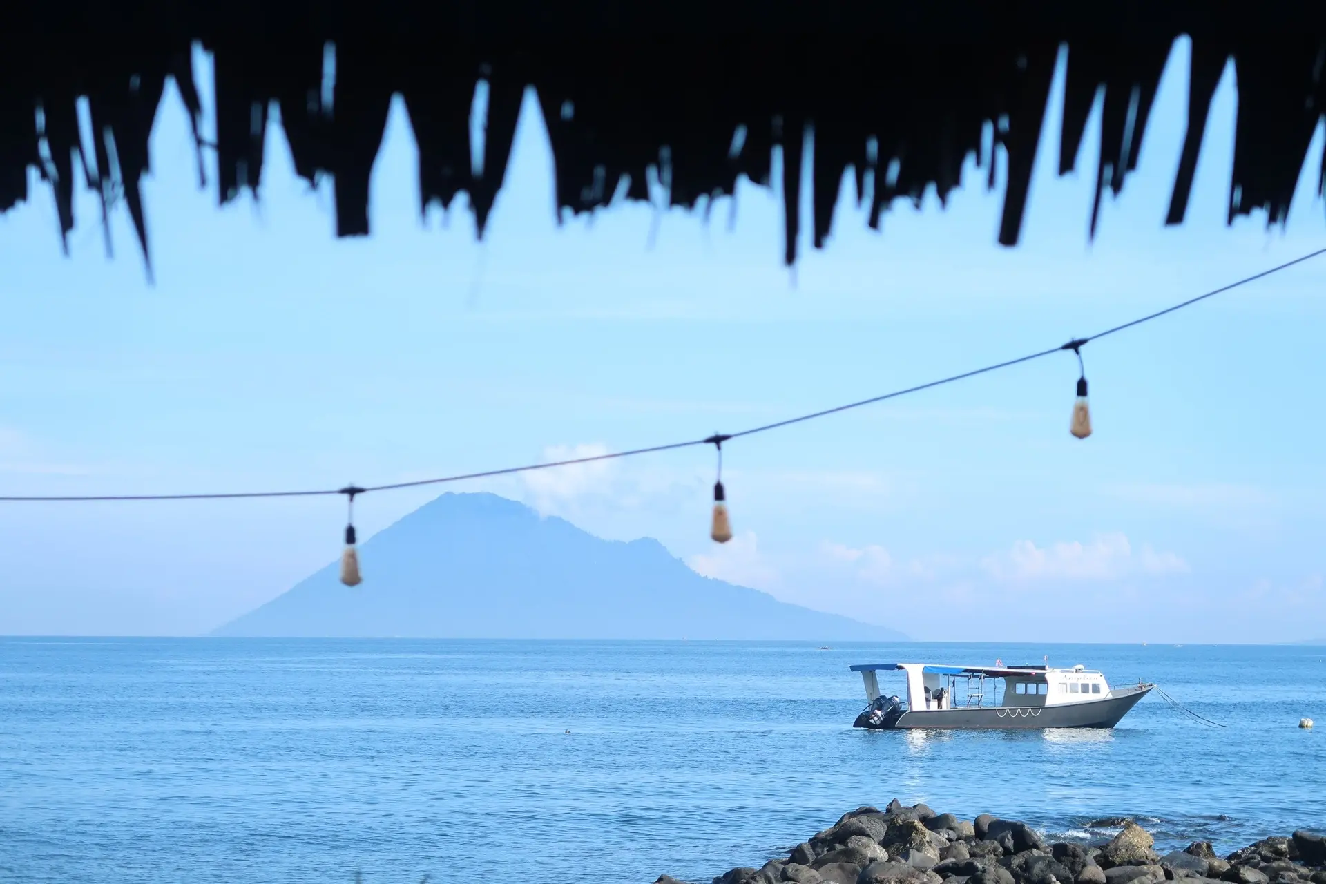 Boat & view of Manado Tua from Murex Manado Resort in Indonesia