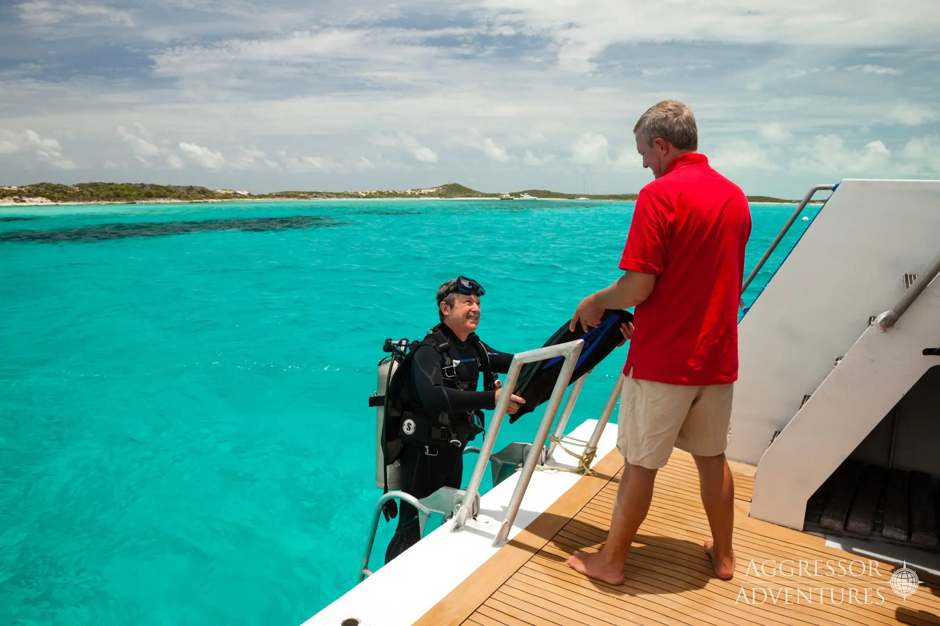 Diver exiting the water onto the Bahamas Aggressor, Bahamas, Caribbean.