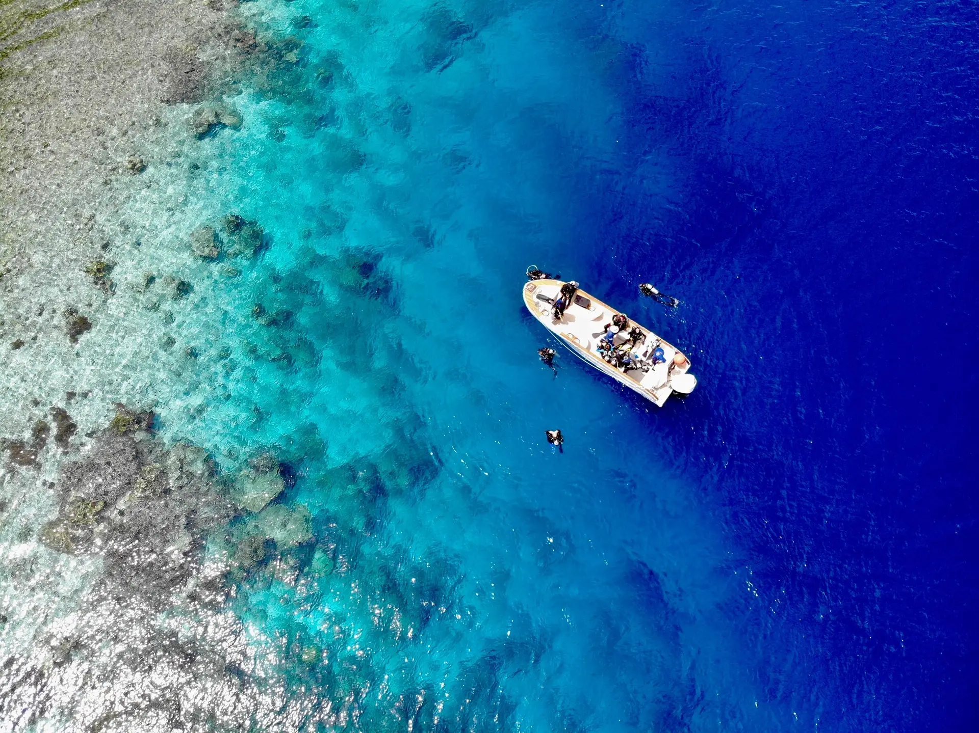 Bird's-eye view of divers & a dive boat in Indonesia