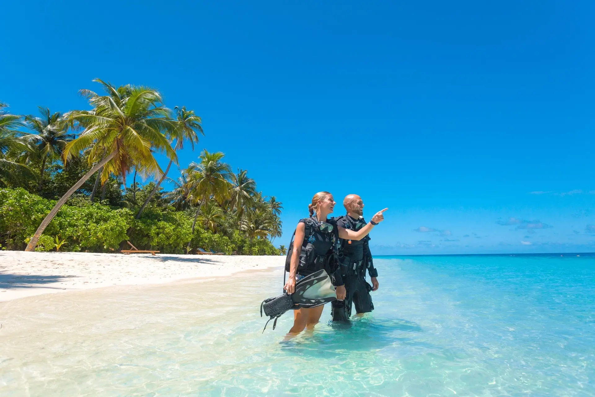 Divers on the shore of the beach at Filitheyo Island Resort in the Maldives