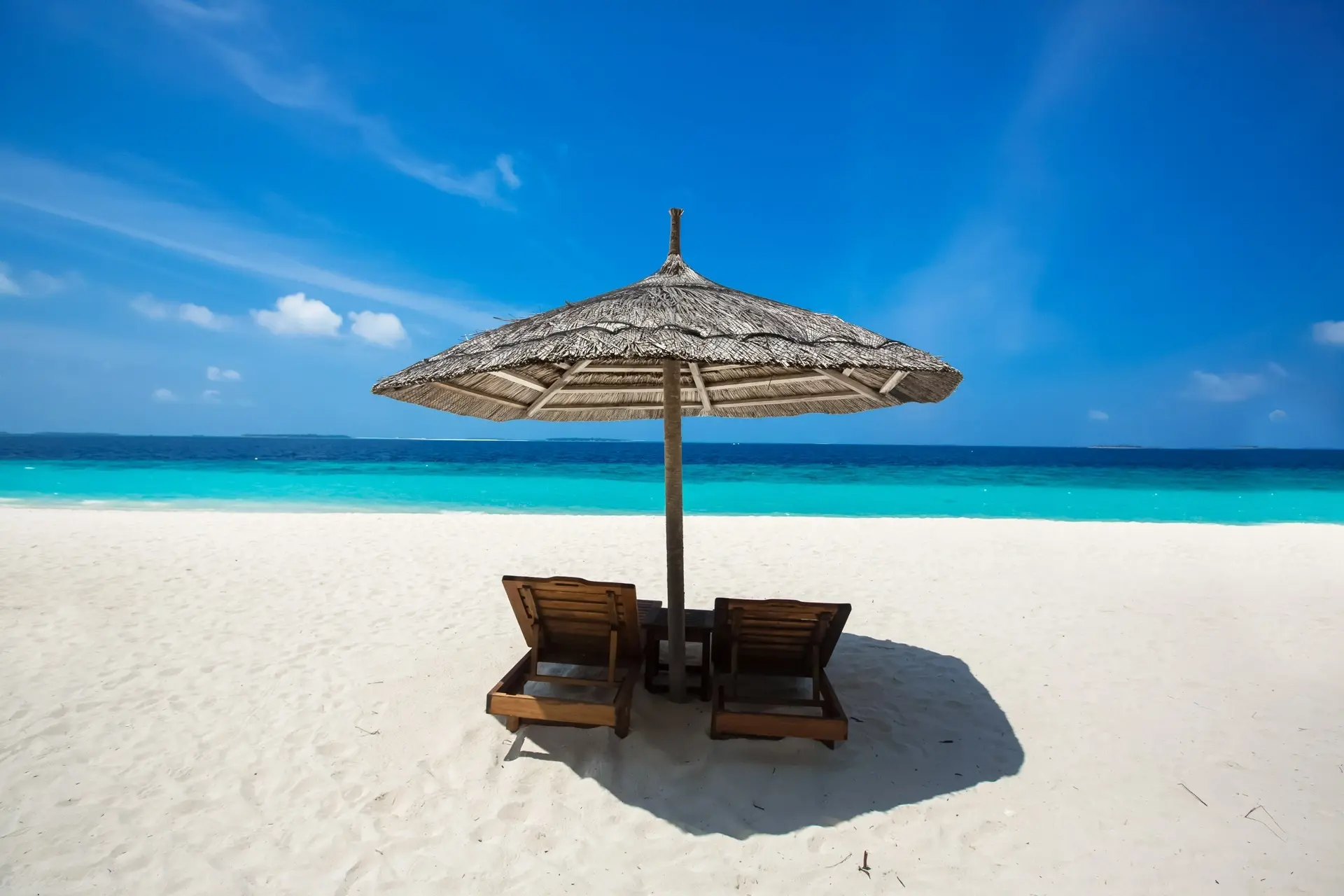 Deck chairs & parasol on the beach at Reethi Beach Resort in the Maldives