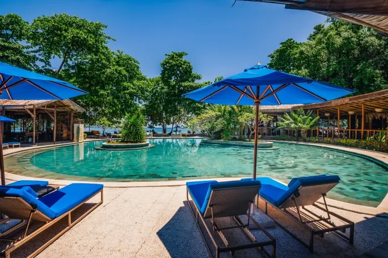Swimming pool & sun loungers at Siladen Resort & Spa in Indonesia
