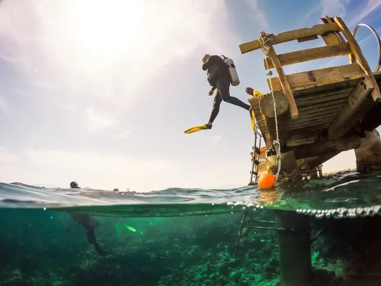 Diver jumping from the jetty at The Breakers Diving & Surf Lodge in Soma Bay, Egypt