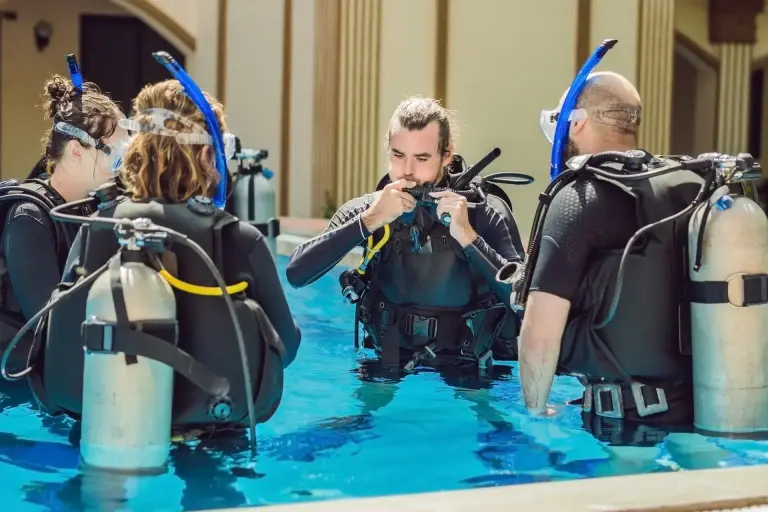 diving instructor and students learning to dive in a swimming pool
