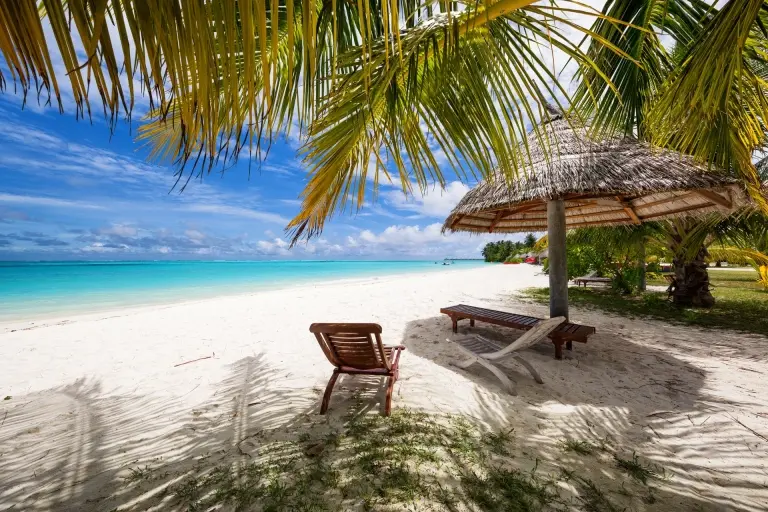 Parasol & sun loungers on a beach in the Maldives
