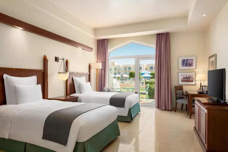 Garden pool view room with twin beds at Wyndham Garden Resort in Mirbat, Oman