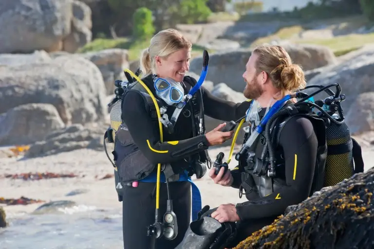 Man and woman checking equipment before diving